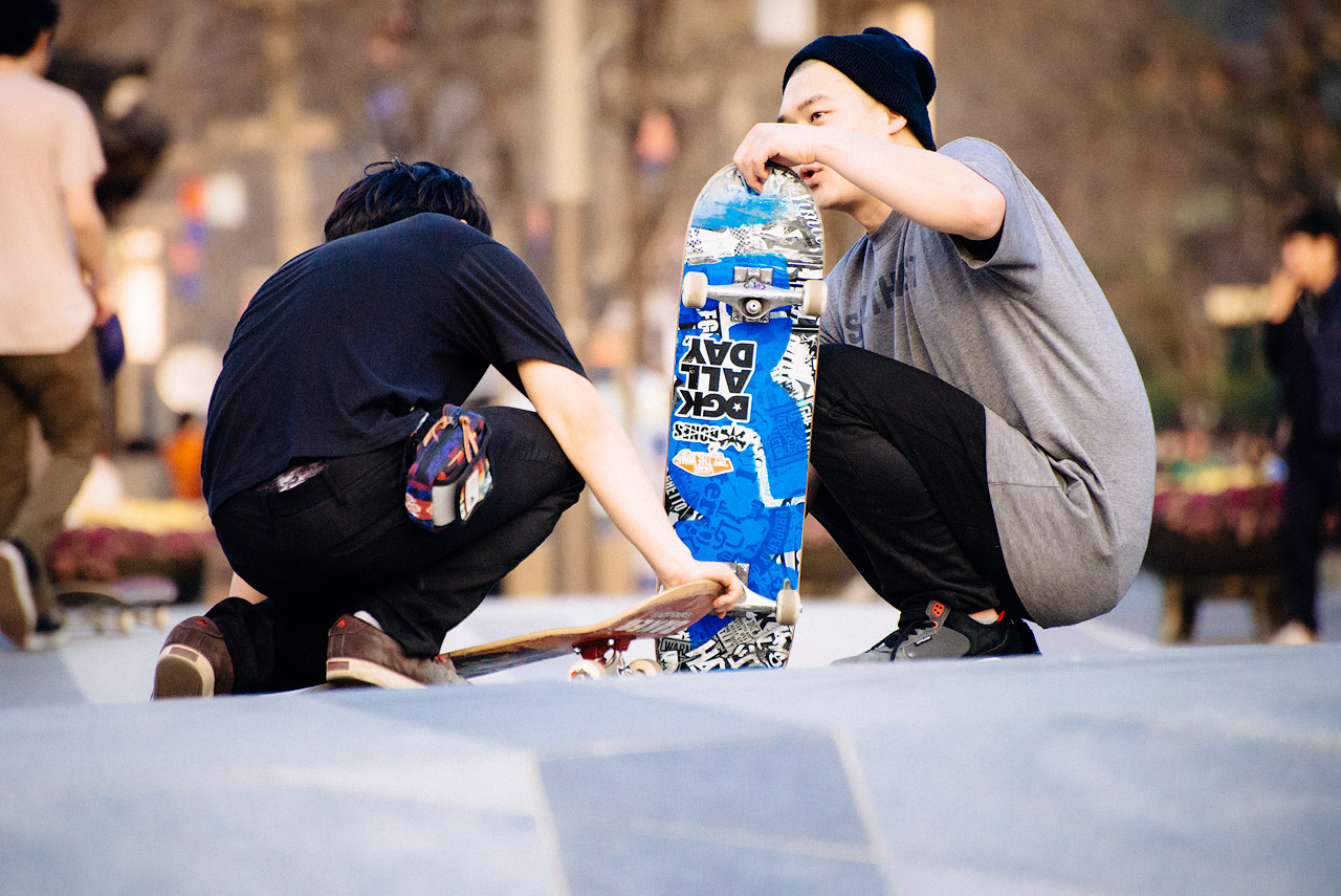 Korean skateboarders inspect their boards